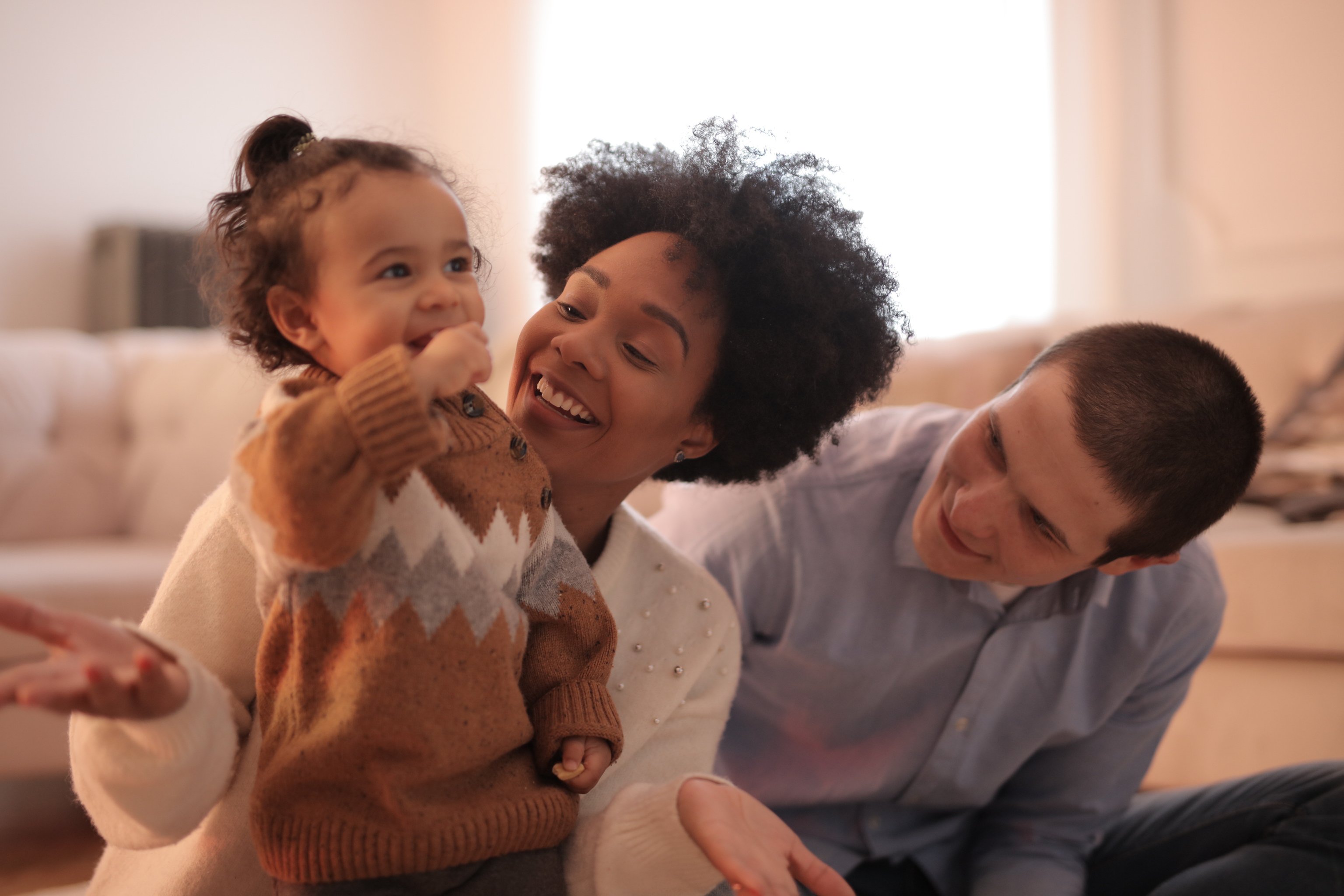 Photo of Man and Woman Having Fun With Their Child